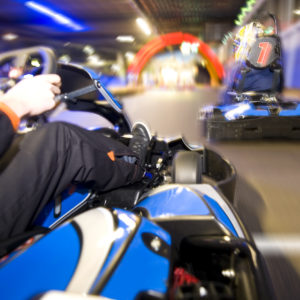 Two go-carts passing the finish line on an indoor race track