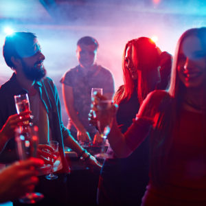 Happy friends toasting at night party