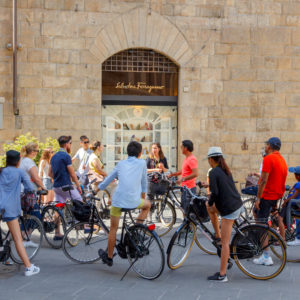 Florence, Italy - May 18, 2015: Tour by bicycle through the streets of Florence. A group of tourists cyclists on the Square of St. Trinita.
