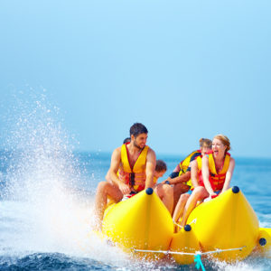 happy people having fun on banana boat