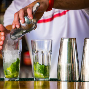 The bartender mixes a summer cocktail at the bar