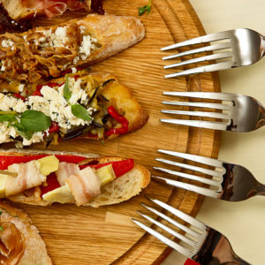 Few spanish tapas are laid on a wooden board