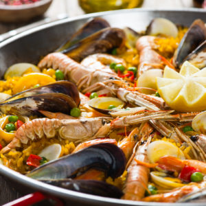 Closeup of spanish paella with shrimp and mussel in a pan. Selective focus. Small deep of focus.