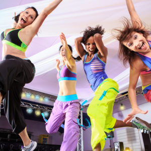 young women in sport dress jumping at an aerobic and zumba exercise