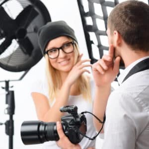 Photoshoot issues. Young male photographer talks with female model about important photoshoot issues
