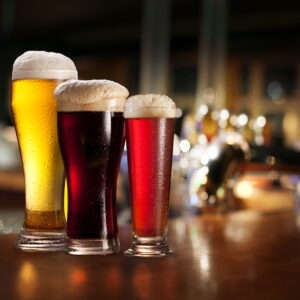 Glasses of light and dark beer on a pub background.